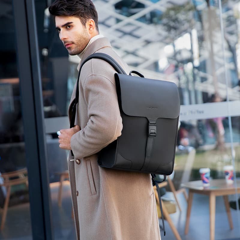 man in trench coat with black shoulder bag