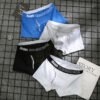 Four-pack of men's cotton boxer briefs in blue, black, white, and grey